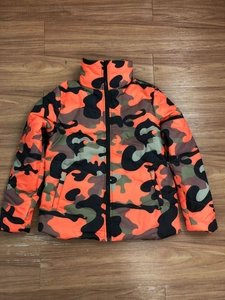 Detailed flat lay of colorful camouflage puffer jacket with orange and green patterns