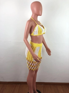 Detail of yellow and white striped crochet beach set featuring hollow knit pattern