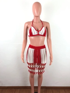 Detail of red and white crochet two-piece set featuring hollow texture and fringe tassels