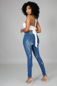 Dettaglio di jeans blu denim alla moda con design artistico di schizzi di vernice colorata