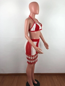 Detail of red and white striped crochet beach set with fringe tassels on model