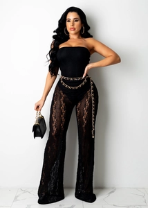 Détails de la combinaison en dentelle noire avec motifs ajourés et ceinture dorée