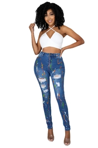 Dettaglio dei jeans skinny con schizzi di vernice colorata e strappi sfrangiati alla moda
