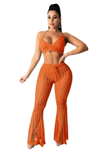 Detail of handmade crochet orange two-piece set featuring hollow mesh pattern and knit texture