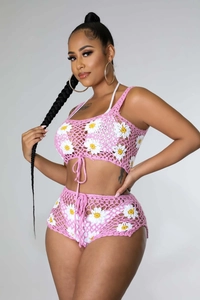 Detalle del conjunto de ganchillo rosa con patrones de margaritas blancas tejidas