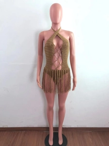 Detail of crochet halter bodysuit with criss-cross ties and long khaki fringe skirt