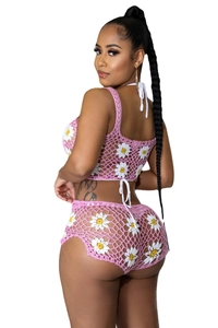 Detalle del conjunto de dos piezas de ganchillo rosa con margaritas blancas en top y short