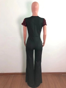 Detail view of the long back zipper and red sequin sleeves on a black wide-leg jumpsuit
