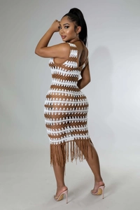 Détail d'une robe au crochet avec rayures tricotées marron et blanc et franges de vacances