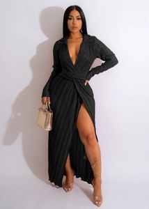 Détail de robe longue plissée noire à manches longues avec décolleté en V et fente haute