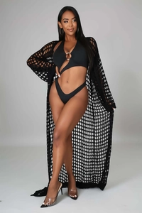 Detail of black crochet knit long beach cover-up and metal buckle bikini set on model