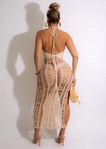 Vista posteriore di un vestito beige all'uncinetto con motivi traforati e schiena nuda