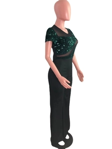 Detail of dark green sequins and sheer mesh patchwork on the short sleeve jumpsuit