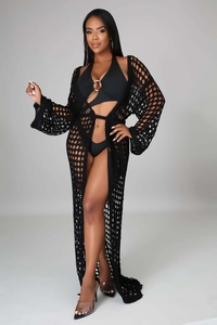 Detail of black crochet cover-up with hollow knit pattern and long beachwear silhouette