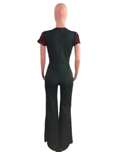 Detail of dark green jumpsuit showing sequin sleeve accents and invisible back zipper closure