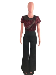 Detail of burgundy sequin top with sheer mesh panel and high-waist black wide-leg pants