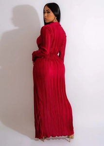 Détail de la texture plissée rouge foncé sur cette robe de soirée élégante à manches