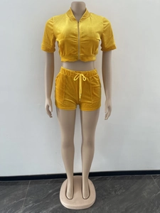 Détail d'un ensemble deux pièces en velours jaune avec haut zippé et short à cordon