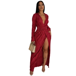 Détail d'une robe plissée rouge foncé avec col en V et fente haute sur la jambe