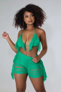 Dettaglio del set da spiaggia all'uncinetto verde con nappe e pantaloncini traforati