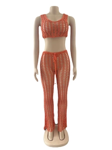 Detail view of orange crochet knit texture on sleeveless top and hollow beach trousers