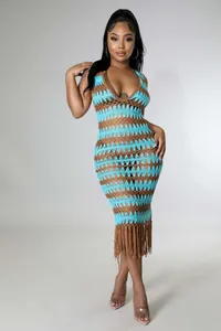 Détail d'une robe de plage en crochet avec motifs bleus ajourés et longues franges
