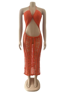 Dettaglio della maglia a uncinetto arancione sul top halter e gonna coordinata con spacco