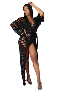Detail of black crochet beach cover-up featuring intricate hollow knit patterns