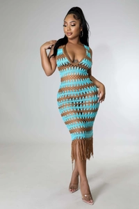 Détail des motifs en crochet et des longues franges sur une robe de plage à rayures turquoise
