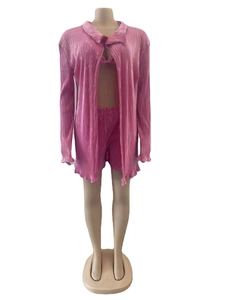 Détail de la texture plissée rose vif sur un ensemble trois pièces pour femme