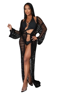 Detail of black crochet beach cover-up featuring hollow-out knit pattern and long sleeves