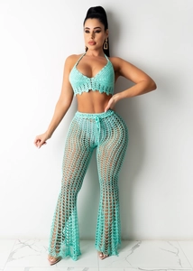 Detail of mint green crochet two-piece set featuring halter top and mesh bell bottoms