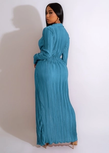 Vue détaillée de la robe plissée bleue à manches longues montrant la texture du tissu