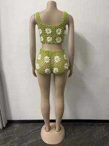 Vista posterior de conjunto de ganchillo verde hecho a mano con margaritas blancas