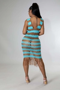 Détail de robe de plage en crochet avec dos nu et longues franges marron sur le bas