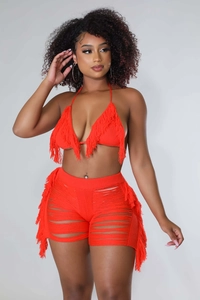 Dettaglio del set due pezzi in maglia all'uncinetto rosso con nappe e stile spiaggia