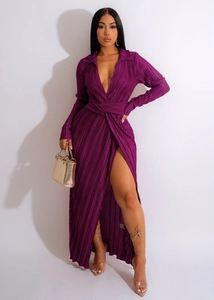 Détail d'une robe maxi plissée violet foncé avec décolleté en V et fente haute à la jambe