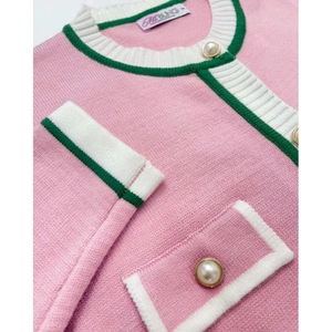 Detail of pink knitted cardigan with contrast trim and elegant pearl buttons