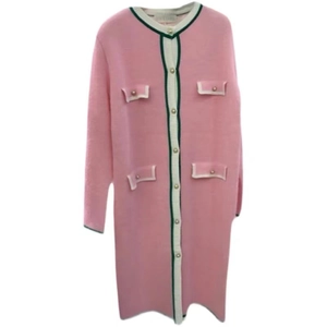 Close-up of pink knit dress with gold pearl buttons and white contrast piping detail