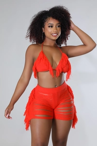 Dettaglio del set da spiaggia rosso all'uncinetto con top a fascia e shorts con nappe