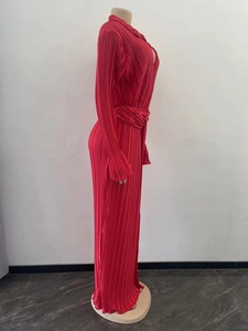 Détail d'une robe longue plissée rouge avec des plis accordéon fins et un fini satiné