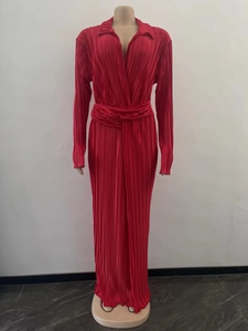 Détail de robe plissée rouge à manches longues avec décolleté en V profond et taille cintrée