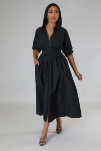 Détail d'une robe chemise midi noire à manches longues avec boutonnage et taille plissée