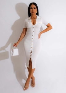 Détail de la robe en maille côtelée blanche avec boutons dorés et col polo classique
