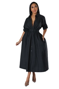 Détail d'une robe chemise noire à manches longues avec boutons et poches latérales