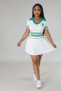 Detailed close-up of the fine vertical knit ribbing on white polo top and pleated skirt
