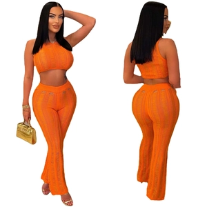 Orange two-piece knit set featuring sleeveless crop top and hollow-out knit pants