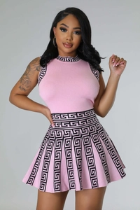 Detailed knit texture of pink sleeveless top and pleated skirt with geometric patterns