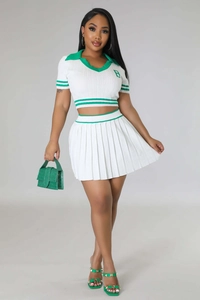 Close-up of white knit polo top with green striped cuffs and matching pleated mini skirt