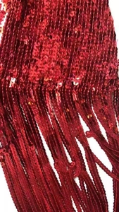Detailaufnahme des roten Pailletten-Fransenstoffs am hoch taillierten Glitzerröck